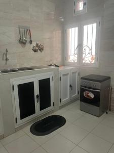 a kitchen with a sink and a stove at TINOU Appart in Dakar