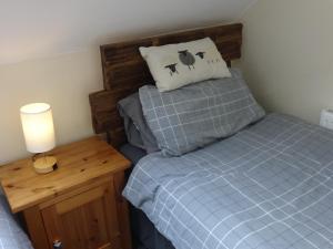 ein kleines Schlafzimmer mit einem Bett und einem Nachttisch in der Unterkunft Riverbank Cottage River Ehan Double Balcony in Egremont