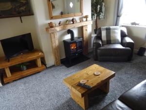 ein Wohnzimmer mit einem Holzofen und einem Sofa in der Unterkunft Riverbank Cottage River Ehan Double Balcony in Egremont + 27 Fotos