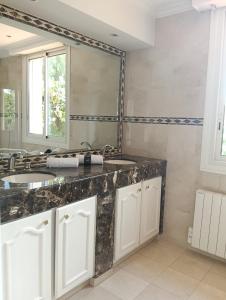 een badkamer met twee wastafels en een grote spiegel bij Villa HELIOS in Cannes +9 foto's