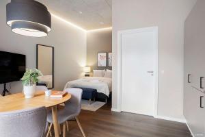 a bedroom with a bed and a table with a tableablish at Cozy Scandinavian Studio with Direct Entry in Aarhus +27 photos