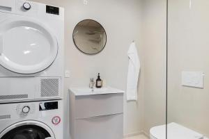 a bathroom with a washing machine and a sink at Cozy Scandinavian Studio with Direct Entry in Aarhus