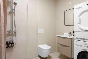 a bathroom with a shower with a toilet and a sink at Ground-Floor Living with Stylish Nordic Interiors in Aarhus