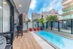 an apartment patio with a swimming pool and a balcony at Lindíssimo Apto em Condominio com Piscina - Bombas in Bombas