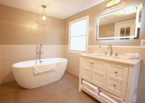 une salle de bain avec une baignoire, un lavabo et un miroir dans l'établissement Riverfront Cottage with Sauna & Hot Tub, à Liberty 17 autres photos
