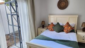 a bedroom with a bed with pillows on it at Peter's Nest in Livingstone