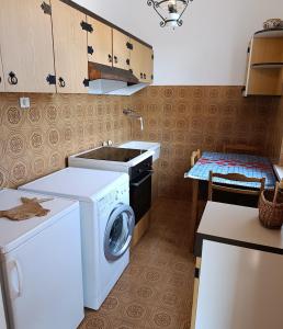 a kitchen with a washing machine and a sink at Casa da Oscar in Marcelli