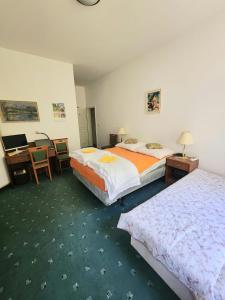 Una habitación de hotel con dos camas y un escritorio. en Plazza Trencianske Teplice Spa Panorama 4P, en Trenčín 44 fotos más