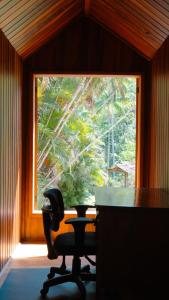 a desk with a chair in front of a window at Casa-chalé da Pedra Furada in Resende