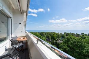 a balcony with a chair and a view of the ocean at Panoramic App C09-8 in Sierksdorf