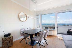 a dining room with a table and chairs and a window at Panoramic App C09-8 in Sierksdorf