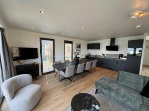 un soggiorno con tavolo e sedie e una cucina di Enkhuizer Strand BeachHouse Odyssee Nr 513 a Enkhuizen