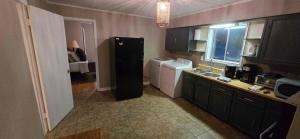 a small kitchen with a refrigerator and a sink at 3 Bedroom Retreat with Modern Comforts and Local Charm in Port Arthur