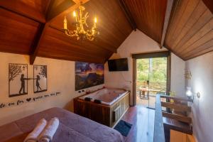 a bedroom with a pool table and a chandelier at Recanto Lira 1 e 3 in Monte Verde