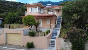 a pink house with stairs leading up to it at IONIAN VIEW HOUSE in Mousata