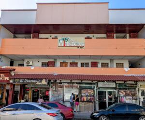 a street with cars parked in front of a store at Hotel Príncipe in La Ceiba