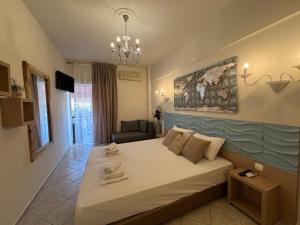 a bedroom with a large bed and a couch at Leonidas Apartments & Suites 2 in Mola Kalyva