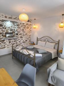 a bedroom with a large bed and a stone wall at Skopelos Sunset traditional country house in Panormos Skopelos