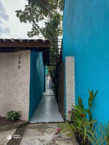 a blue building with a blue wall and a walkway at Linda suíte à 300m da Praia do Pequeá no Saco da Capela in Ilhabela