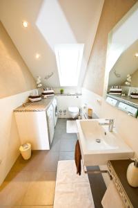 an attic bathroom with a sink and a toilet at Design-Wohnungen by Ulrike Horster in Bensheim