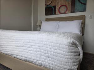 un letto con lenzuola e cuscini bianchi in una camera da letto di Minimalist Lake House a Helendale Altre 34 foto