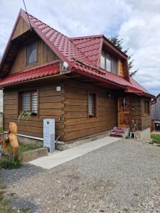 ein kleines Holzhaus mit rotem Dach in der Unterkunft Chalupa nad sadom in Liptovská Kokava