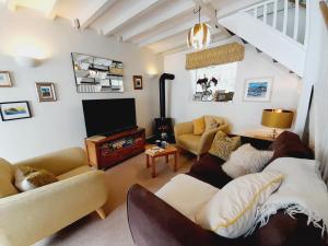 a living room with couches and a flat screen tv at Crab Cottage in Ilfracombe