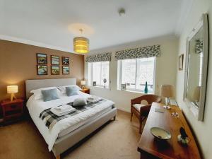 a bedroom with a bed and a desk and a table at Crab Cottage in Ilfracombe