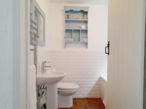 a white bathroom with a toilet and a sink at Crab Cottage in Ilfracombe +15 photos