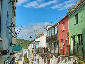 a city street with colorful buildings and mountains in the background at Crab Cottage in Ilfracombe