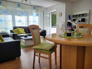 a living room with a table with a bottle of wine at Bodensee Idylle in Friedrichshafen +8 photos