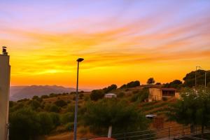a street light with a sunset in the background at SamolisApartment in Anogeia