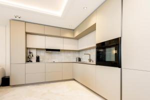 a kitchen with white cabinets and a skylight at Playa Miraflores Luxury Beachfront Apartment in Mijas Costa