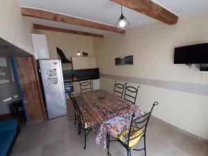 a kitchen with a table with chairs and a refrigerator at Lotus in Cébazan