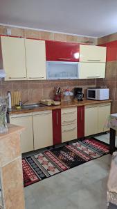 a kitchen with white cabinets and a kitchen rug at Casa Sara in Eforie Nord