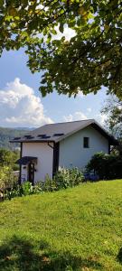 una casa blanca sentada en la cima de un exuberante campo verde en Legit House, en Yaremche