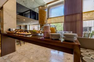 a breakfast table with plates of food on it at Hotel Majestic Rosario in Rosario
