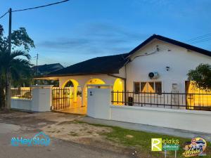a white house with yellow doors and a fence at Villa 5R3B 23 Pax Swimming Pool Karaoke BBQ Town Area in Kelebang Besar