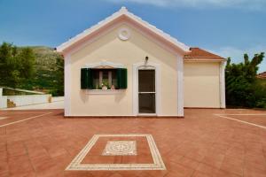 a small white house with a window in a driveway at Villa Joya in Makriótika