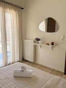 a white room with a white towel on the floor at Nostos Apartment Galatas in Galatas +23 photos