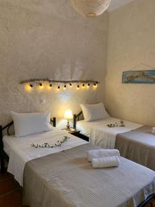 a room with two beds with white sheets at AMPELIA KYTHIRA in Livadi