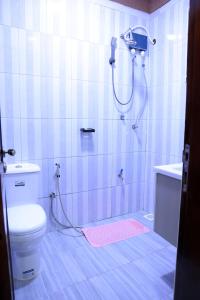a bathroom with a shower with a toilet and a sink at AG Home Studio - Kampala in Kampala