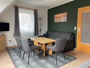 un salon avec une table, des chaises et un canapé dans l'établissement Ferienwohnungen Wiek, Haus Luv & Lee, à Wiek auf Rügen