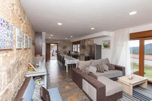 a living room with a couch and a kitchen at A Raxeira de Jose in Campañó