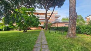 un parco con panchina e un edificio di Violet Luni Home a Marinella di Sarzana