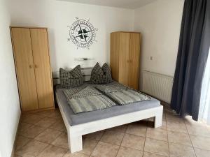 - une chambre dotée d'un lit avec une horloge murale dans l'établissement Ferienwohnungen Wiek, Haus Luv & Lee, à Wiek auf Rügen