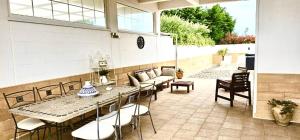 a patio with a table and chairs and a couch at Polignano Villa with Jacuzzi, Garden & Parking in Polignano a Mare