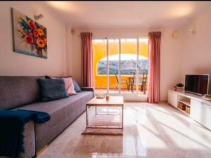 a living room with a couch and a table at Apartmán Marcella, Cumbre del Sol in Cumbre del Sol