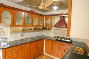 库玛拉孔Grand Villa Houseboat的厨房配有木制橱柜和吊扇