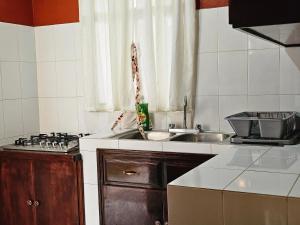 a small kitchen with a sink and a stove at Santa Cecilia Casa elegante acogedora y amplia in Tehuacán +4 photos
